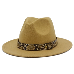 Macro detail of camel wool fedora hat featuring snakeskin leather band with gold studs