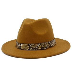 Detail view of camel wool fedora hat featuring snake print leather band and gold metal rivet