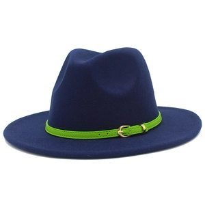 Detail of navy blue wool fedora hat featuring a green leather band and gold metal buckle