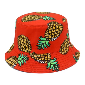 Close-up of red cotton sun hat featuring vibrant cartoon pineapple patterns and reinforced brim