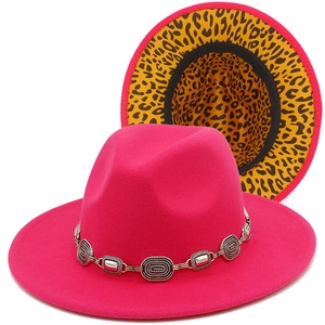 Detailed view of hot pink fedora featuring silver chain and yellow leopard print brim