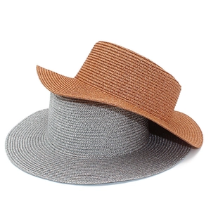 Detail view of shimmering silver and bronze straw sun hats with fine woven metallic texture