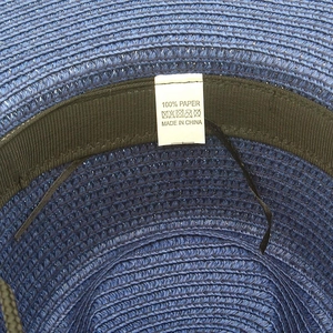 Gros plan de l'intérieur d'un chapeau de paille bleu avec étiquette 100% papier