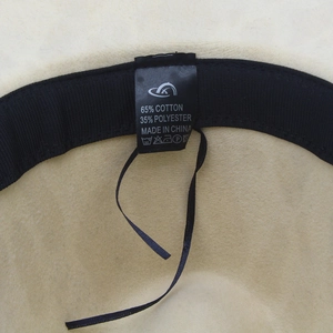 Macro shot of fedora hat interior showing the 65% cotton fabric label and sweatband