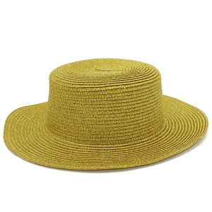 Shiny golden straw sun hat with wide brim and flat top for stylish summer beach wear