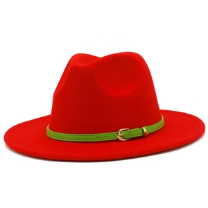 Detail of red wool fedora featuring a green leather band and golden buckle finish