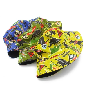 Detail of three colorful cotton sun hats featuring vibrant cartoon dinosaur prints