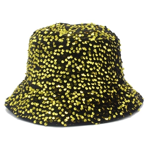 Dettaglio delle paillettes dorate su un cappello a secchiello nero per look da festa