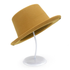 Classic mustard yellow flat top felt hat for men and women on a white display stand