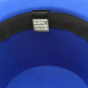 Detail view of royal blue fedora hat interior showing label and polyester cotton blend material