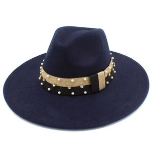 Detail of wide brim fedora hat featuring black gold band with pearls and rhinestones