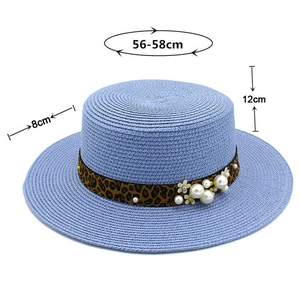 Detailed view of wide brim straw hat with leopard ribbon, pearls and dimensions 56-58cm
