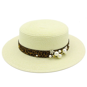 Detail of boater straw hat with leopard ribbon, pearls and floral accents for beach