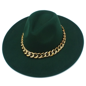 Détail du chapeau fedora vert foncé à larges bords avec une grosse chaîne dorée cubaine