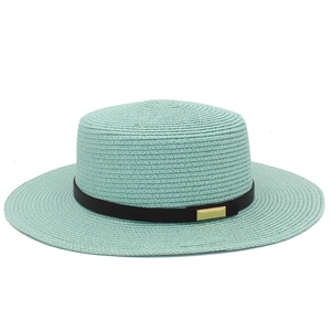 Détail d'un chapeau de paille vert menthe avec bande en cuir noir et métal doré
