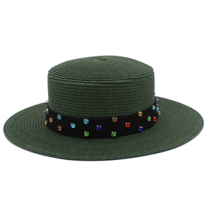 Détail du chapeau de paille vert foncé à dessus plat avec ruban de strass colorés