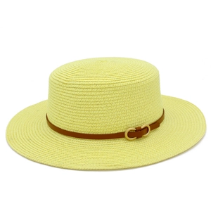 Détail du chapeau de paille d'été avec bande en cuir marron et boucle en métal doré