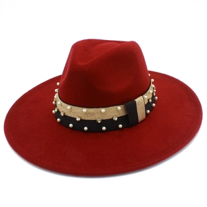 Detail of burgundy fedora with black-gold ribbon, white pearls, and rhinestones