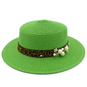 Close-up of woven straw hat with leopard print ribbon and white pearl daisy accents