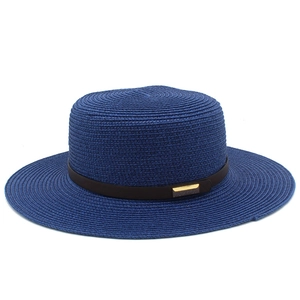 Détail d'un chapeau de paille bleu foncé avec ruban en cuir marron et boucle dorée