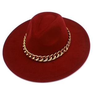 Détail d'un chapeau fedora bordeaux à large bord avec une chaîne en métal doré chic