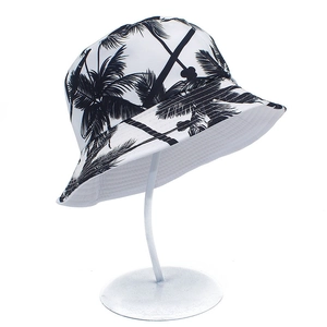 Detailed close-up of double-sided bucket hat with palm tree print on white metal stand