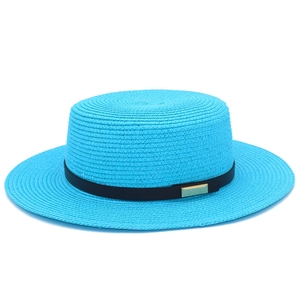Détail du chapeau de paille bleu avec ruban noir et boucle métallique dorée élégante
