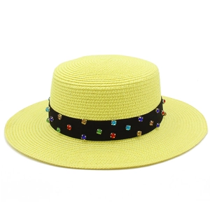 Détail d'un chapeau canotier jaune en paille avec ruban noir et strass colorés brillants