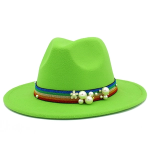 Detail of lime green wool fedora hat with rainbow ribbon and pearl decorations