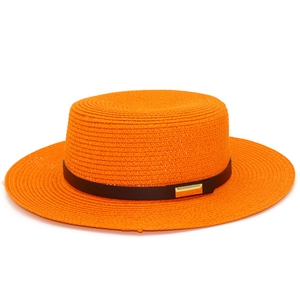 Détail du chapeau de soleil en paille orange vif avec ruban noir et boucle dorée élégante