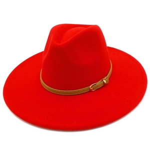 Detail of red wool fedora featuring light brown leather band and gold buckle