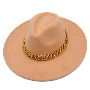 Détail d'un chapeau fedora à larges bords avec chaîne dorée et texture en feutre
