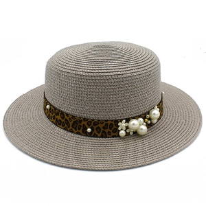Detailed top view of a flat top straw boater hat with leopard print ribbon and pearl accents