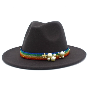 Close-up of brown wool fedora with colorful ribbon, pearls and floral embroidery