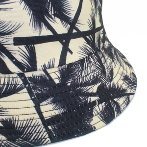 Close-up of the beige canvas bucket hat featuring black palm tree prints and fine stitching