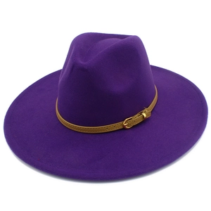 Macro view of dark purple wide brim wool fedora hat with brown leather buckle strap