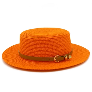 Detail of orange woven straw boater hat with brown leather belt and gold heart buckle