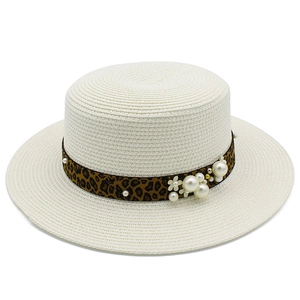 Detail of straw sun hat with leopard ribbon, pearls and floral accents for beach