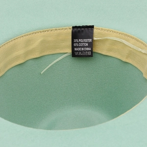 Close-up of mint green fedora inner lining with sweatband and 65% cotton label