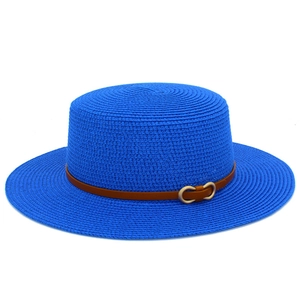 Détails de la texture du chapeau de paille bleu avec bande en cuir marron et boucle dorée