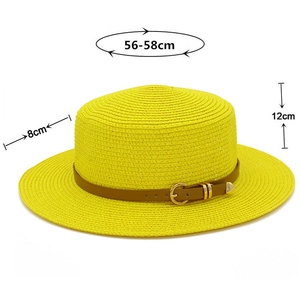 Detail of yellow straw boater hat with brown leather band and gold heart buckle