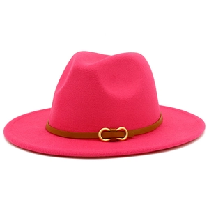 Detail of fuchsia wool fedora hat featuring a brown leather band and gold metal buckle