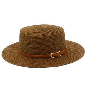 Détails d'un chapeau canotier marron à bord plat avec boucle en métal et texture tressée