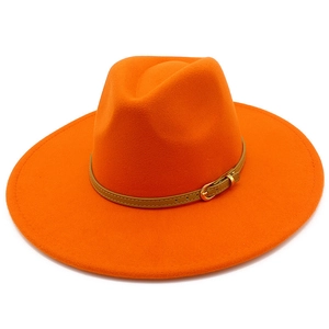 Detailed view of an orange wide-brim fedora hat with a brown leather decorative band