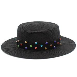 Détail du chapeau canotier noir en paille avec des strass colorés sur le ruban