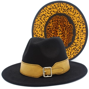 Detail view of black fedora hat with orange leopard print underbrim and leather belt buckle