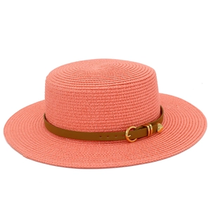 Detail of coral pink straw hat with brown leather band and gold heart buckle
