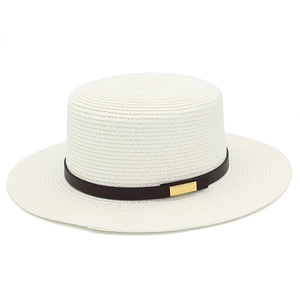 Détail d'un chapeau de paille blanc avec bande en cuir foncé et boucle dorée