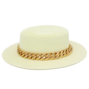 Détails de la texture du chapeau canotier blanc avec une grosse chaîne en métal doré