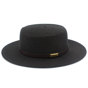 Détail d'un chapeau de paille noir avec ruban en cuir marron et boucle dorée